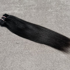 Black hair bundle on a gray surface