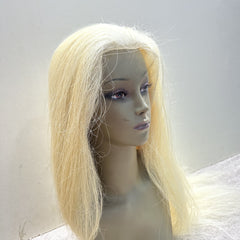 Blonde wig on a mannequin head against a plain background