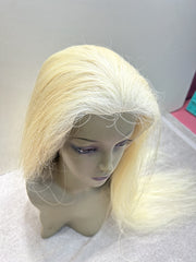 Blonde wig on a mannequin head against a plain background