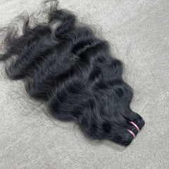 Black hair extensions on a gray surface