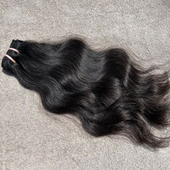 Black hair extensions on a gray surface