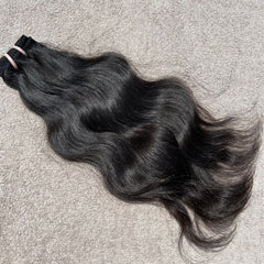 Black hair extensions on a gray surface